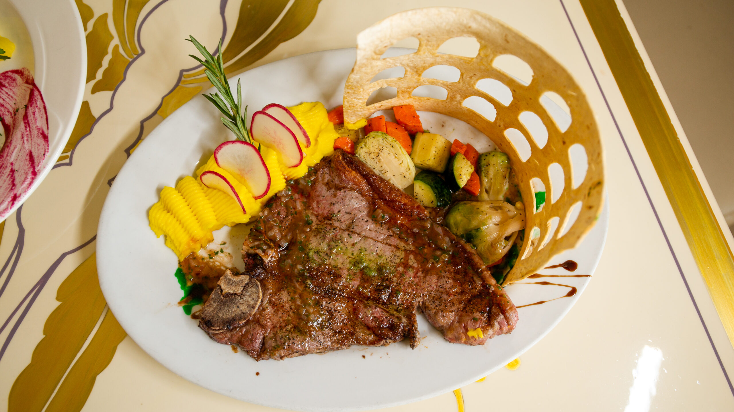 Gourmet meal with a large piece of meat and vegetables on the plate