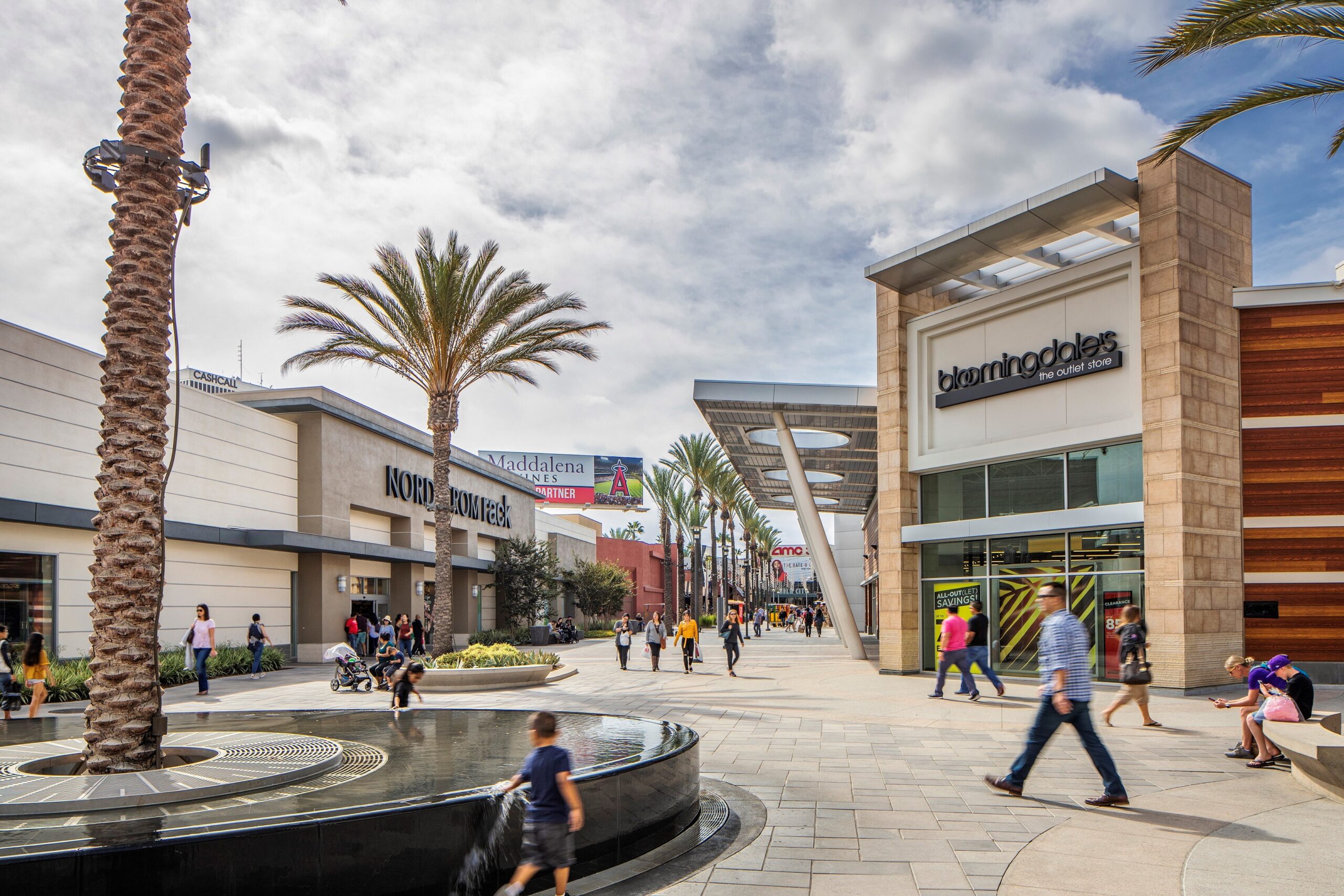 People walking around the outside walkways at the Outlets at Orange